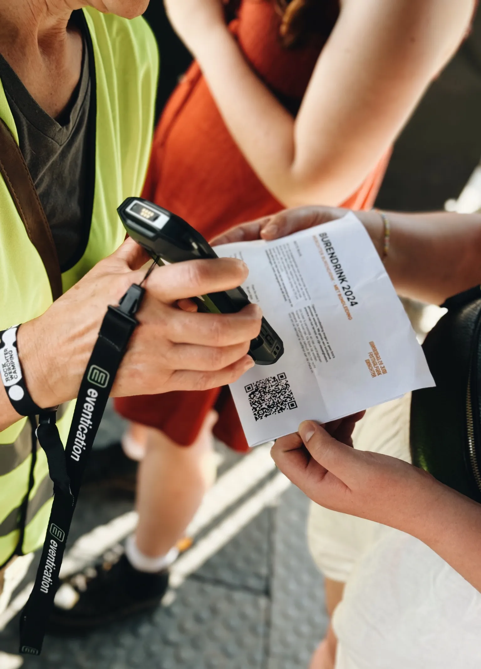 An event team member scanning a printed QR code with a handheld scanner