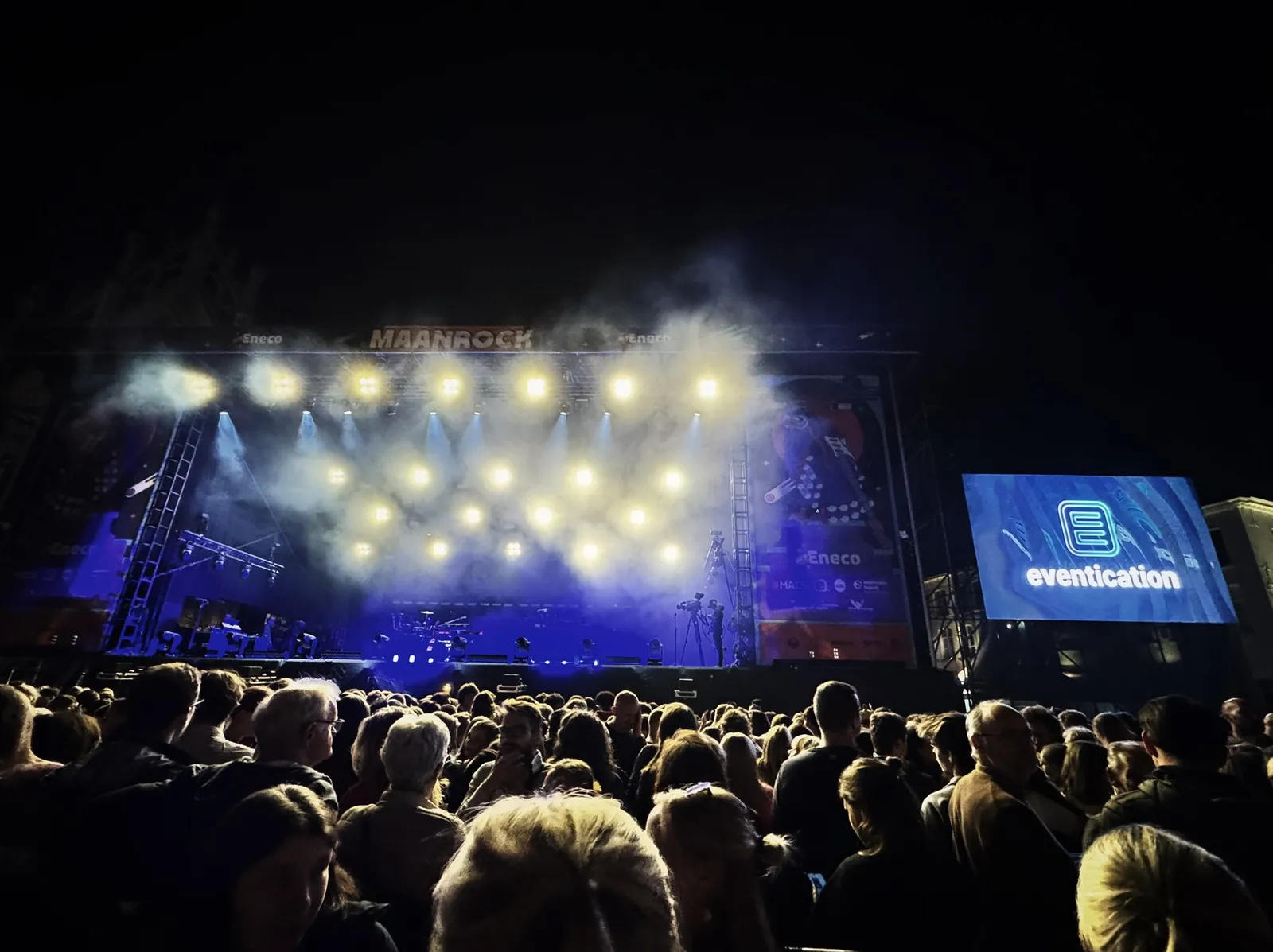 Crowd watching the Maanrock stage at night, with Eventication displayed on the side screen.